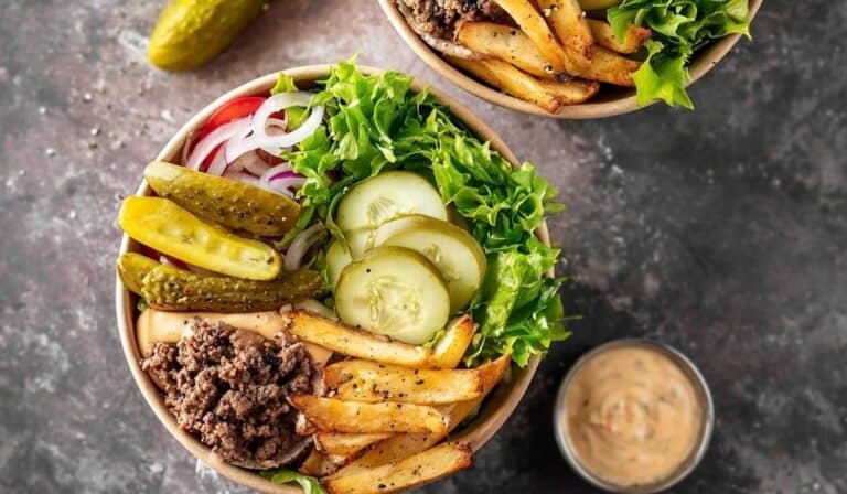 Burger Bowls with lettuce, fries, pickles, ground beef, and sauce in a rustic brown bowl