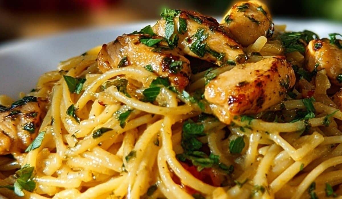 Monterey Chicken Spaghetti in a baked dish topped with herbs