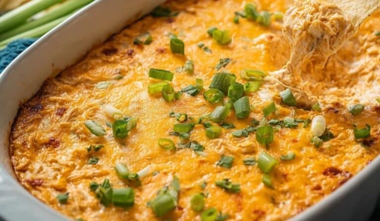 Best Buffalo Chicken Dip baked with melted cheese and green onions in a casserole dish