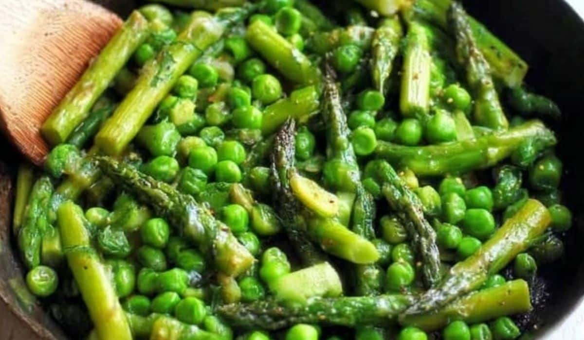 Asparagus and pea saute in a skillet with garlic and olive oil