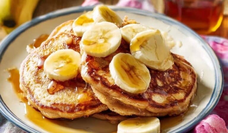 Banana Pancakes topped with sliced bananas and maple syrup