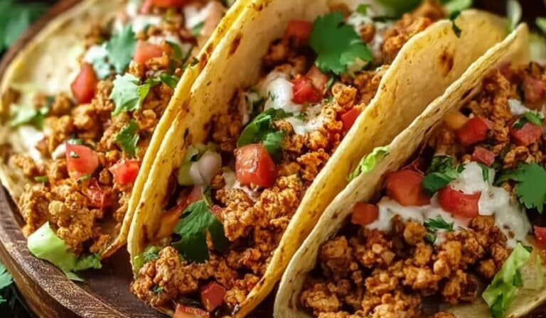 Ground Turkey Tacos served on a wooden plate with fresh cilantro and tomatoes