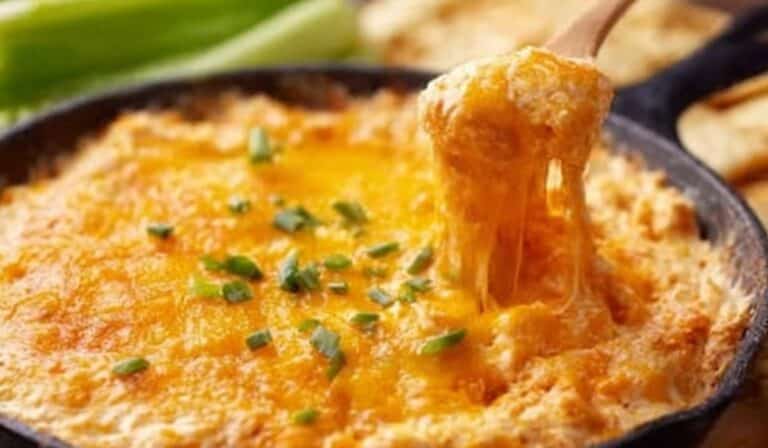 Easiest Buffalo Chicken Dip baked in skillet with melted cheese and celery sticks