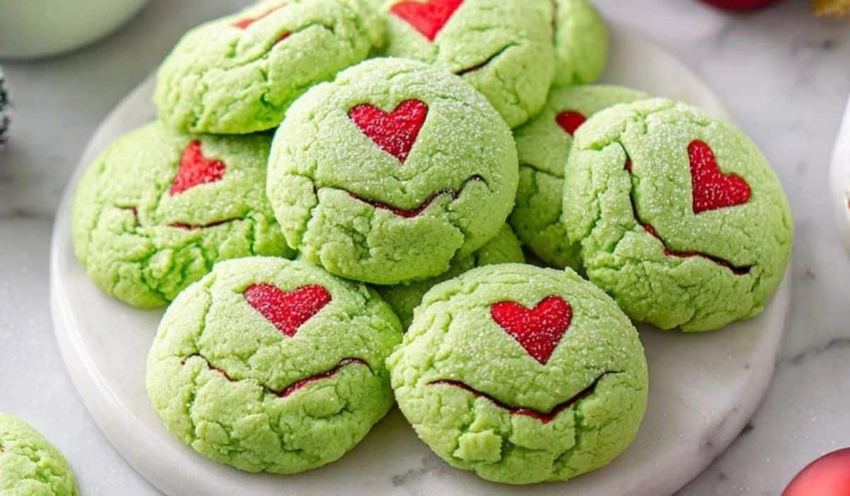 Grinch Cookies with red hearts on white plate for Christmas