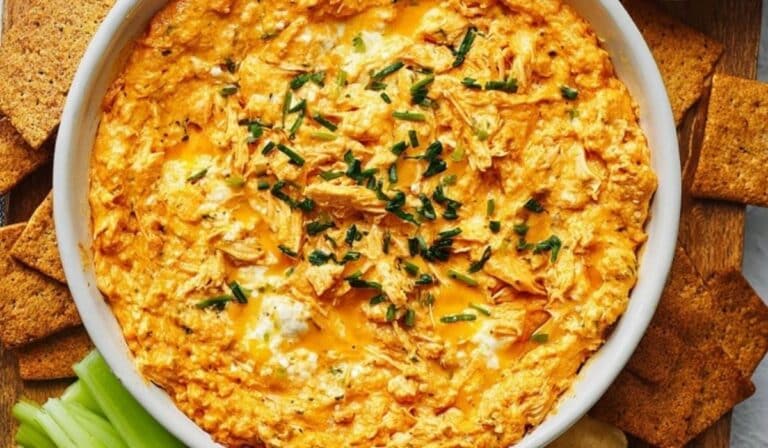 High Protein Buffalo Chicken Dip served with crackers and celery in white bowl