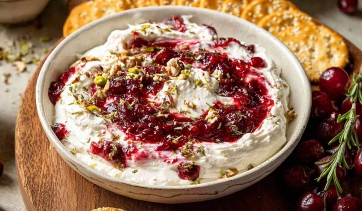 The Best Cranberry Whipped Feta Dip in a bowl with cranberry sauce and crackers