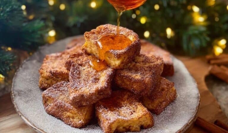 Eggnog French Toast Bites served with syrup and powdered sugar