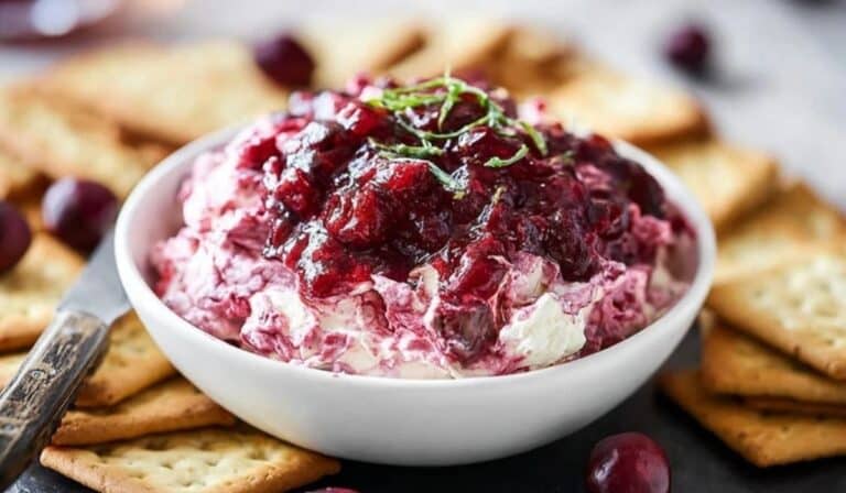 Irresistible Cranberry Cream Cheese Dip served in white bowl with crackers