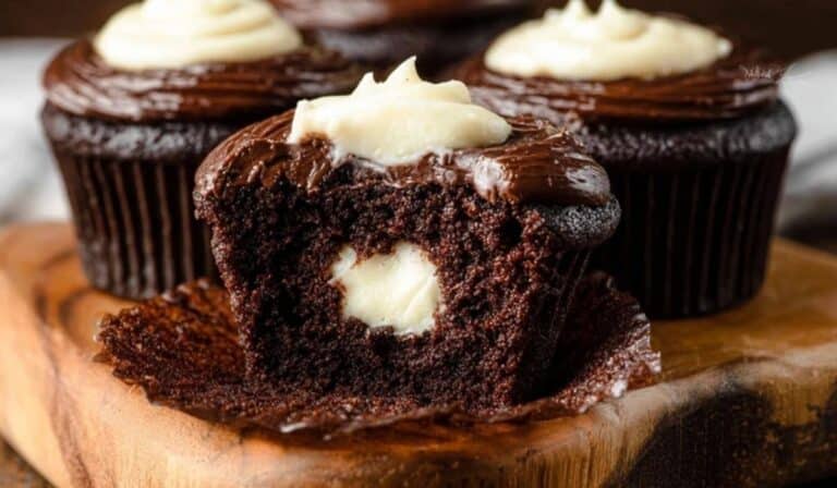 Cream-Filled Chocolate Cupcakes on wooden dessert stand with cream filling