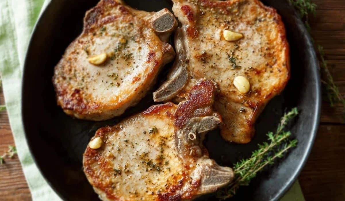 Pan grilled pork chops in cast iron skillet with garlic and thyme