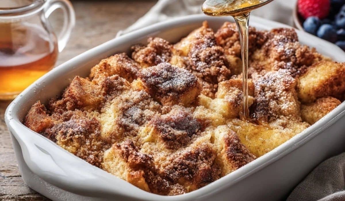 Baked French toast casserole in a baking dish with berries and syrup