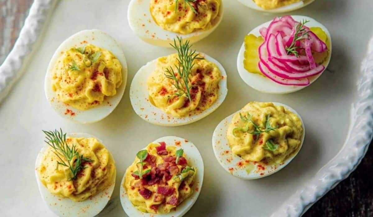 Classic deviled eggs 3 ways on a platter with paprika, dill pickle, and bacon chive toppings