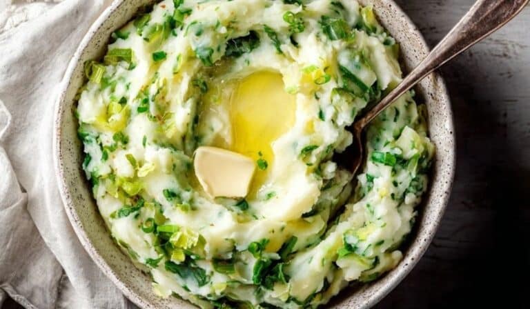 Colcannon (Irish mashed potato) in a bowl with melted butter and green onions