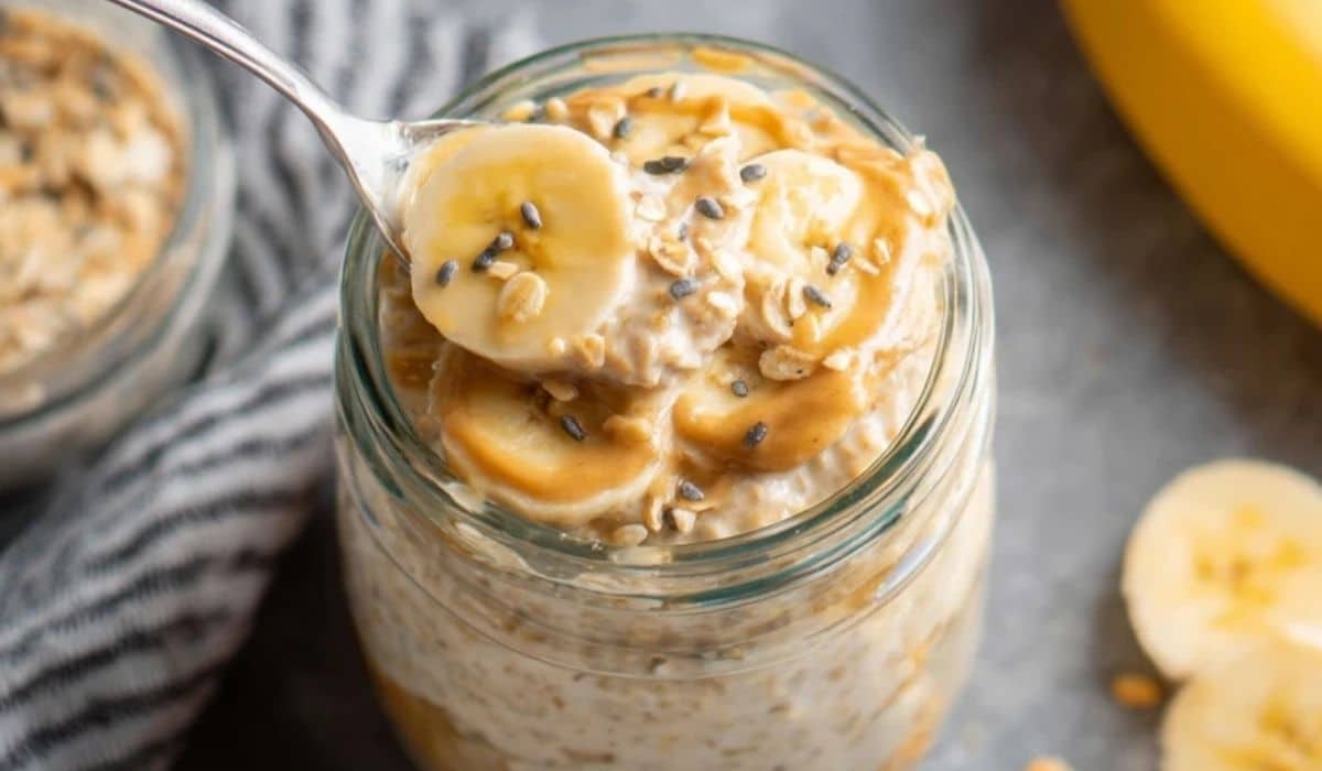Overnight protein oats with banana in a jar topped with sliced bananas and peanut butter